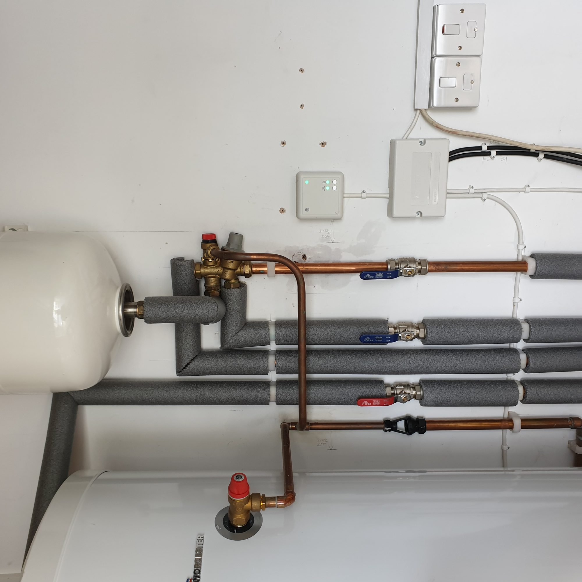 Central heating installation with hot water cylinder, blending valve, lagged pipework and labelled isolation valves
