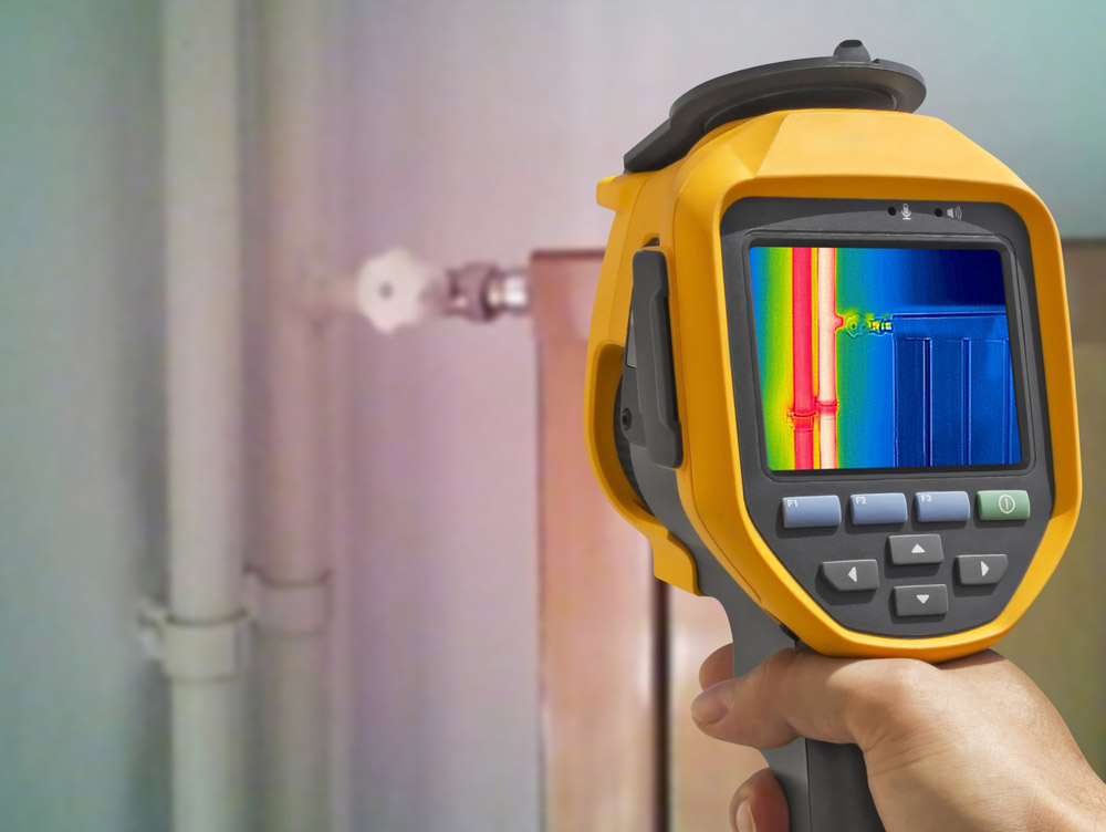 Thermal imaging camera used for leak detection, showing a hot spot on concealed pipework