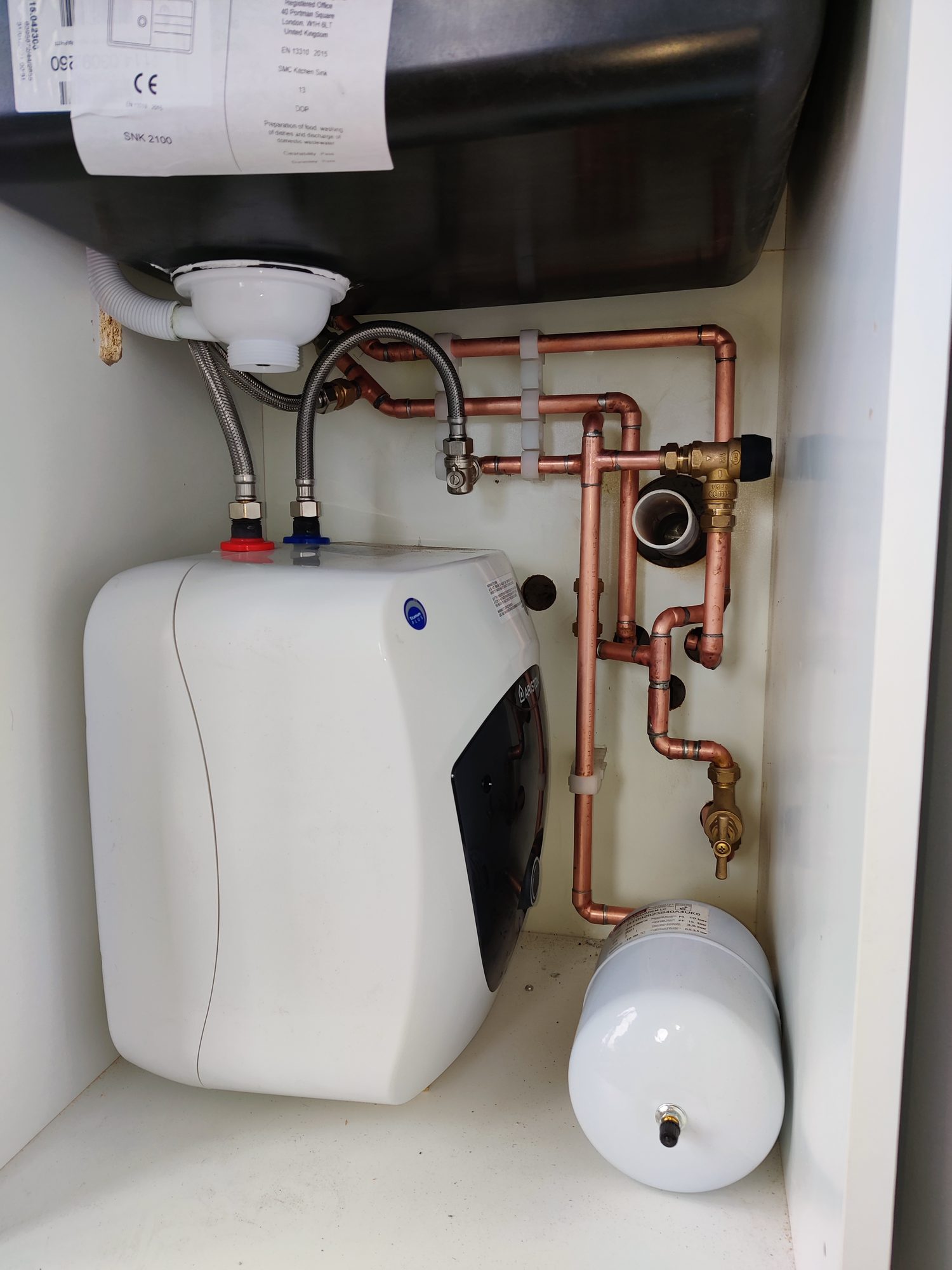 General plumbing installation: under-sink water heater with expansion vessel and copper pipework