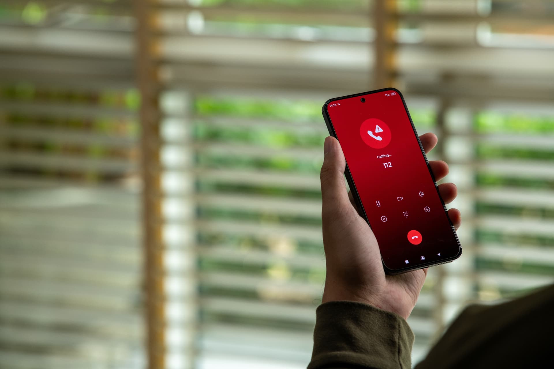 Hand holding a phone mid-call, illustrating an emergency plumbing and heating call-out