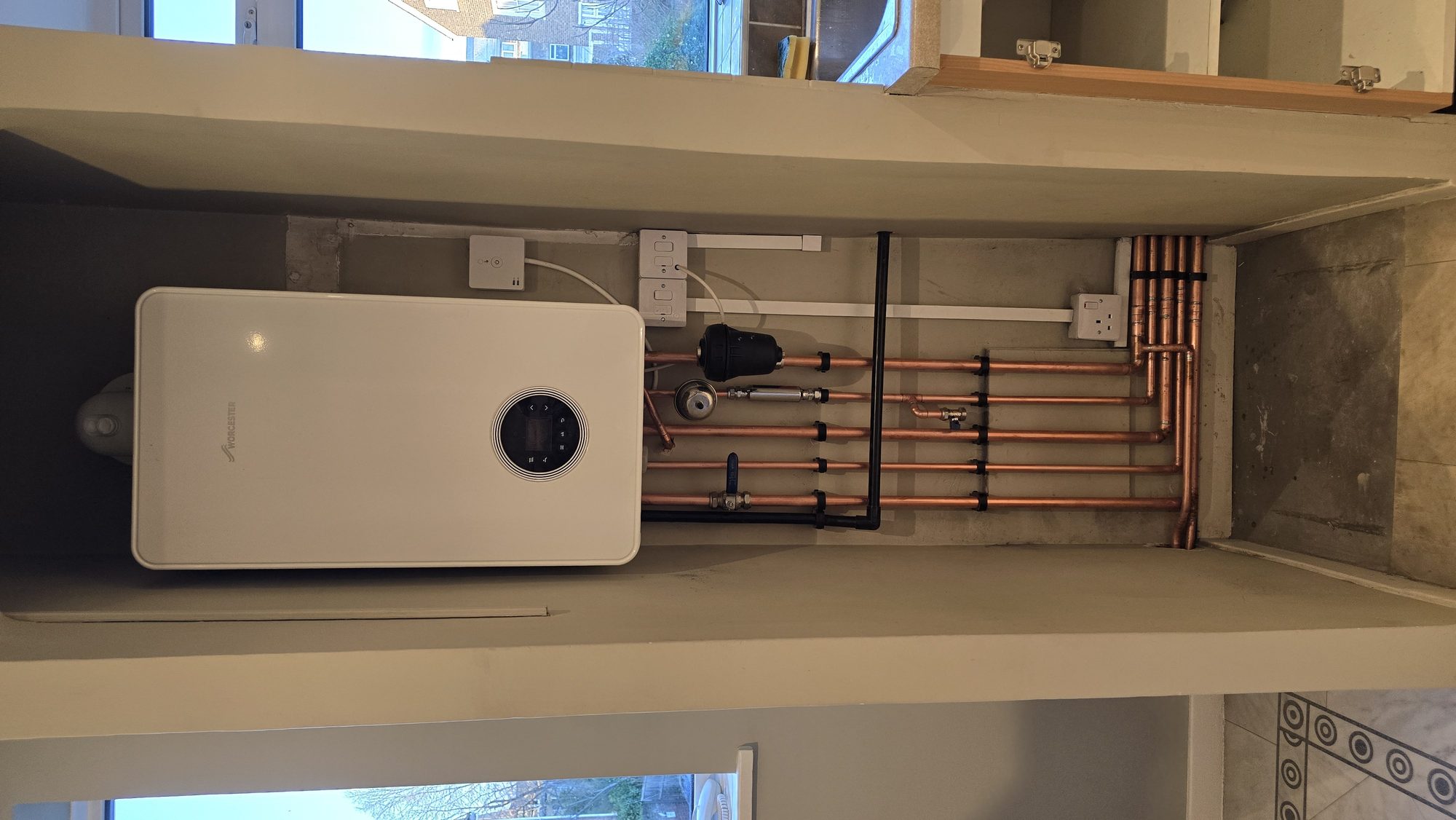 Worcester boiler installation inside a kitchen cupboard with concealed copper pipework and system filter